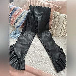 Black ruffled bottom cropped pleather pants.